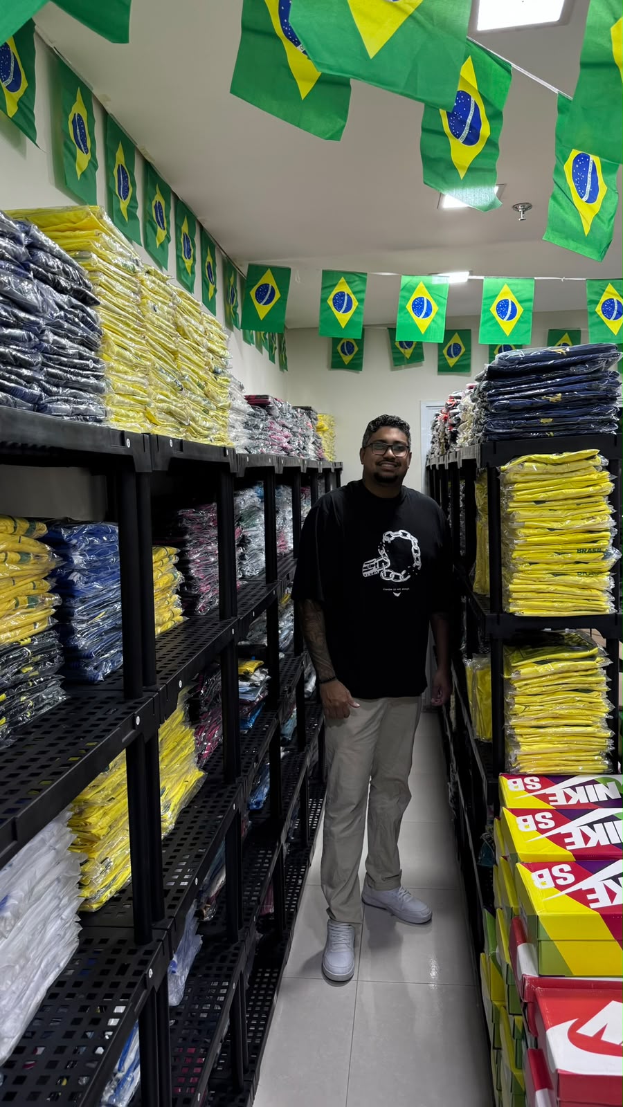 Fernando Dutra junto às prateleiras de camisas